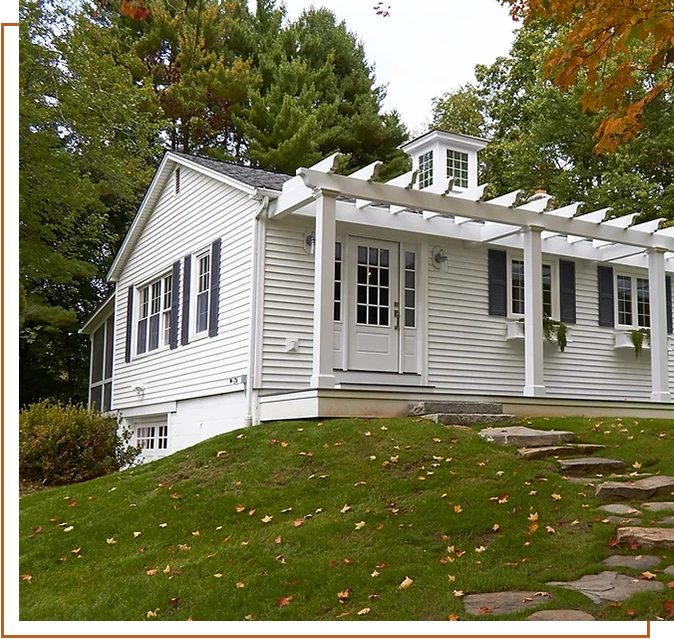 A white house sitting on top of a green hill.