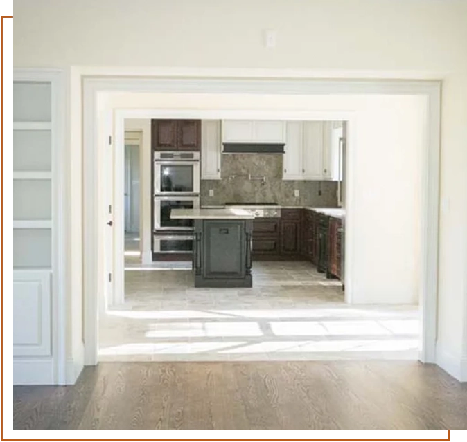 A kitchen with an open door and white walls.