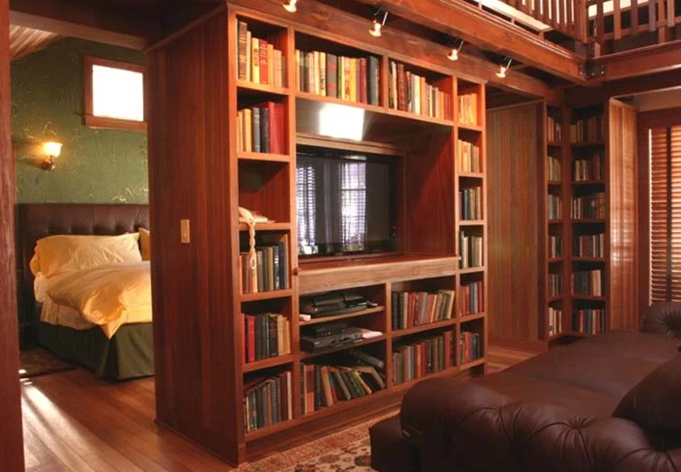 A television and bookcase in the corner of a room.