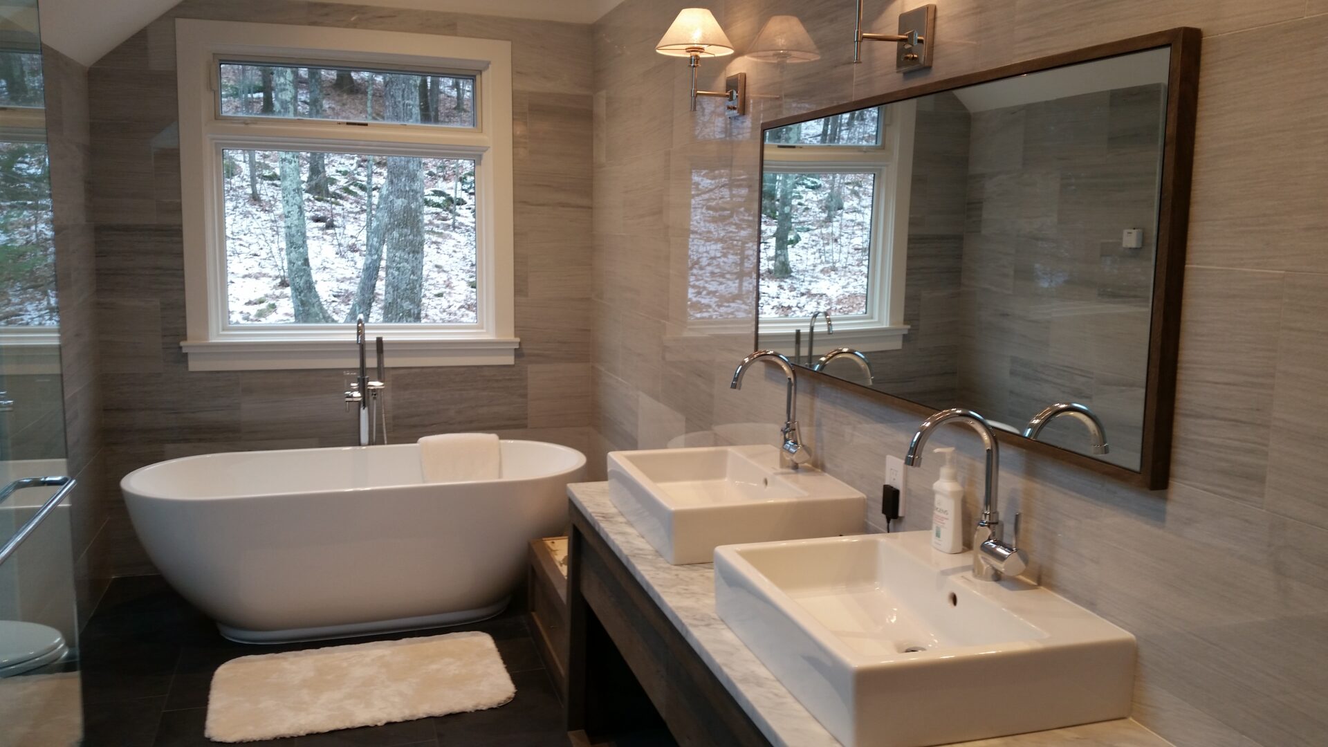 A bathroom with two sinks and a tub.